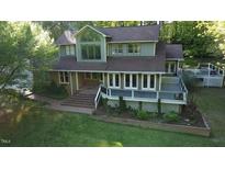 Charming two-story home features a spacious deck and manicured lawn surrounded by mature trees at 2000 Mountain Laurel Dr, Clayton, NC 27527