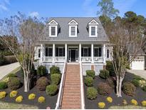 Charming home with white columns, covered porch, brick steps, and professionally landscaped front yard at 227 Walford Way, Cary, NC 27519