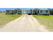 Exterior view of charming duplex homes with gravel driveway and manicured lawn, evoking curb appeal at 30 Chaney Ln, Louisburg, NC 27549