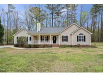 Charming single-story home with a welcoming front porch, complemented by a well-maintained yard and mature trees at 340 Castleberry Rd, Clayton, NC 27527