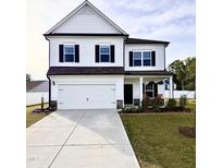 Charming two-story home with a two-car garage, well-manicured lawn and inviting front porch at 5117 Farm Barn Ln, Raleigh, NC 27603