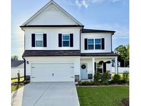 Charming two-story home with a well-maintained lawn, garage, and welcoming light blue front door with wreath at 5117 Farm Barn Ln, Raleigh, NC 27603