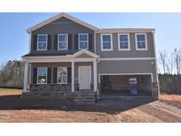 Two-story home featuring a gray exterior with stone accents and an attached garage at 55 Cordoba Dr, Franklinton, NC 27525