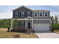 Charming two-story home featuring gray siding, black shutters, and an attached two-car garage at 55 Cordoba Dr, Franklinton, NC 27525