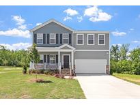 Charming two-story home with a manicured lawn, covered front porch, and attached two-car garage at 55 Cordoba Dr, Franklinton, NC 27525