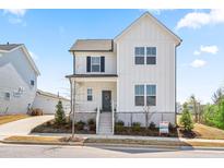 Charming two-story home with a modern farmhouse design and a well-manicured front yard at 5800 Agrinio Way, Raleigh, NC 27603