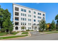 Stunning exterior view of a white brick condo building boasting multiple balconies and beautiful landscaping at 620 Wade Ave # 506, Raleigh, NC 27605