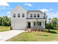 Charming two-story home featuring a covered porch and a two-car garage, set on a well-maintained lawn at 65 Cordoba Dr, Franklinton, NC 27525