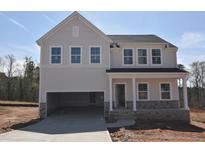 Two-story home with gray siding, stone accents, attached two-car garage and covered front porch at 65 Cordoba Dr, Franklinton, NC 27525