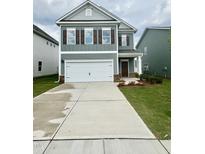 Charming two-story home with a two-car garage and well-maintained front lawn at 76 Commons Cir, Clayton, NC 27520