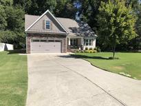 Charming home with a stone-accented garage, inviting front porch, and well-manicured lawn at 79 Hillgrove Dr, Willow Springs, NC 27592