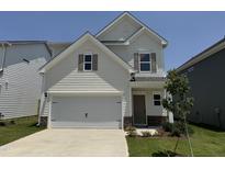 Charming two-story home with a two-car garage, stone accents, and a well-manicured lawn at 84 Commons Cir, Clayton, NC 27520