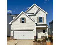 Charming two-story home featuring light siding, a two-car garage, and complemented by stone accents at 84 Commons Cir, Clayton, NC 27520