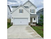 Charming two-story home featuring a spacious two-car garage and manicured lawn at 84 Commons Cir, Clayton, NC 27520