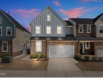 Charming two-story home featuring stone accents and an attached two-car garage with a long driveway at 8410 Zinc Autumn Path, Raleigh, NC 27615