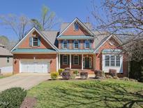 Beautiful brick home with blue shutters and a manicured front lawn at 8417 Henderson Rd, Apex, NC 27539