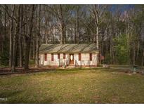 Charming single-story home with a well-manicured lawn and mature trees creating a serene setting at 900 Cricket Knoll Rd, Fuquay Varina, NC 27526