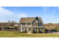 Charming two-story home featuring gray siding, stone accents, and a well-manicured lawn at 1036 Butterfly Cir, Wake Forest, NC 27587