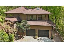 Stunning two-story house with a two-car garage and beautiful wood exterior nestled in a lush forest setting at 111 Standing Rock Rd, Chapel Hill, NC 27516