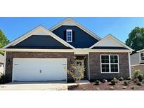 Charming single-Gathering home featuring stone and blue siding, a two-car garage, and a well-manicured lawn at 1914 Malvina Ct, Graham, NC 27253