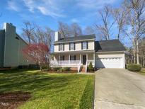Charming two-story home with a welcoming front porch, well-manicured lawn, and an attached two-car garage at 23 Round Spring Ln, Durham, NC 27712
