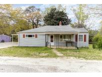 Charming single-story home with light grey siding, a covered porch, and red window shutters at 5324 Rock Quarry Rd, Raleigh, NC 27610