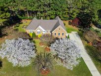 Stunning aerial view of brick home, mature trees, and a well-manicured front yard at 6521 Vintage Ridge Ln, Fuquay Varina, NC 27526