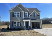 Charming two-story home featuring gray siding and a convenient attached one-car garage at 74 Harvest Hills Ln, Dunn, NC 28334