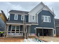 Two-story home featuring a two-car garage, a gray facade, white trim, and construction in progress at 779 Old Station Pointe, Angier, NC 27501