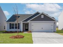 Charming single-story home with a manicured lawn, attached garage, and inviting front entrance at 12 Crow Field St, Roxboro, NC 27574