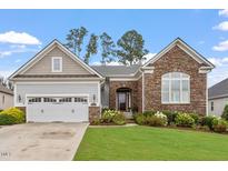 Charming single Gathering home featuring a stone facade, manicured lawn, and attached two car garage at 2554 Club Level Dr, Apex, NC 27523