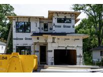 New construction home exterior featuring the garage door and protective wrap before the exterior finish is applied at 2603 Vineyard St, Durham, NC 27707