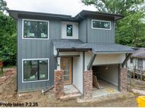 Modern two-story home boasts a stylish gray exterior, large windows, and a brick-accented garage at 2603 Vineyard St, Durham, NC 27707