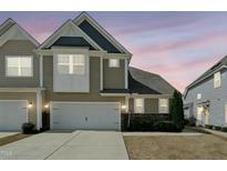 Two-story townhome with a white garage door, stone accents and neat landscaping at 310 Shale Creek Dr, Durham, NC 27703