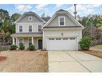 Charming two-story home with a gray roof, a well-manicured lawn, and a spacious two-car garage at 318 Sylvias Ct, Durham, NC 27703