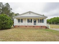 Charming single-story home with a welcoming front porch, white siding, and blue shutters at 327F Bobbitt Rd, Clayton, NC 27520