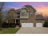 Charming two-story brick home featuring a three-car garage and manicured landscaping at 401 Molina Ct, Rolesville, NC 27571