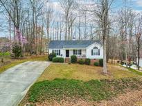 Charming one-story home with a well-manicured lawn, inviting front porch and long driveway at 6208 Silver Spring Ct, Willow Springs, NC 27592