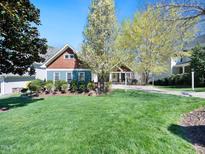 Charming home featuring a well-manicured lawn, colorful landscaping, and a welcoming front porch at 904 Hidden Jewel Ln, Wake Forest, NC 27587