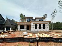 Modern home under construction features large windows and contemporary design elements, sitting on a spacious lot at 95 Cherry Bark Dr, Youngsville, NC 27596