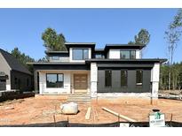 Modern home under construction with a flat roof, double-door entryway, and horizontal siding details at 95 Cherry Bark Dr, Youngsville, NC 27596