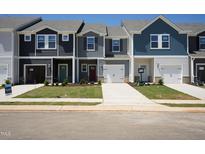 Row of new two-story townhomes with driveways, lawns, and varied siding and door colors at 1169 Abbott St, Mebane, NC 27302