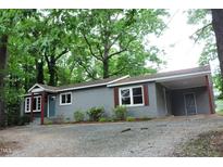 Charming single-story home featuring a brick facade, inviting blue door, and a covered parking area at 1212 St. Marys Rd, Hillsborough, NC 27278