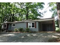 Charming brick home featuring a carport, fresh landscaping, and a welcoming entrance at 1212 St. Marys Rd, Hillsborough, NC 27278