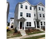 New construction, two-story townhome featuring stone accents, neutral colors, and a covered entryway, ready for move-in at 3007 Honeymyrtle Ln, Durham, NC 27703