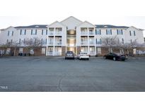 Apartment building featuring balconies, complementary parking and well-maintained landscaping with flowering trees at 3031 Winston Dr # Apt 302, Burlington, NC 27215