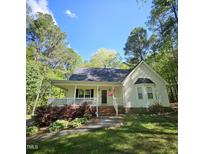 Inviting home with a classic front porch, bay window, and beautifully landscaped yard, all nestled among mature trees at 4116 Tall Pine Dr, Franklinton, NC 27525