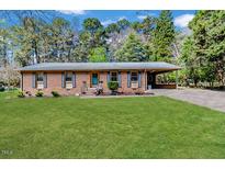 Charming single-story brick home with a well-maintained front yard and covered parking at 412 Winterlocken Dr, Sanford, NC 27330