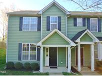 Charming two-story townhome featuring green siding, black shutters, and a welcoming covered front porch at 4425 Moss Garden Path, Raleigh, NC 27616