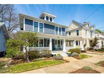 Charming blue two-story home boasts a welcoming front porch and manicured landscaping at 620 Wills Forest St, Raleigh, NC 27605
